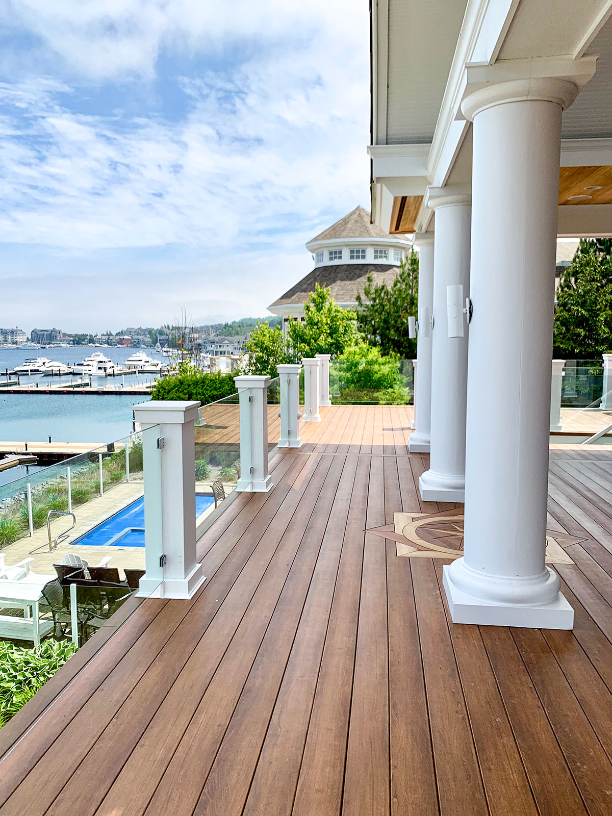 Completed waterfront deck with glass railing and white columns